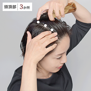 前髪の生え際から頭頂部に向かって髪をかき分け3か所塗布します。